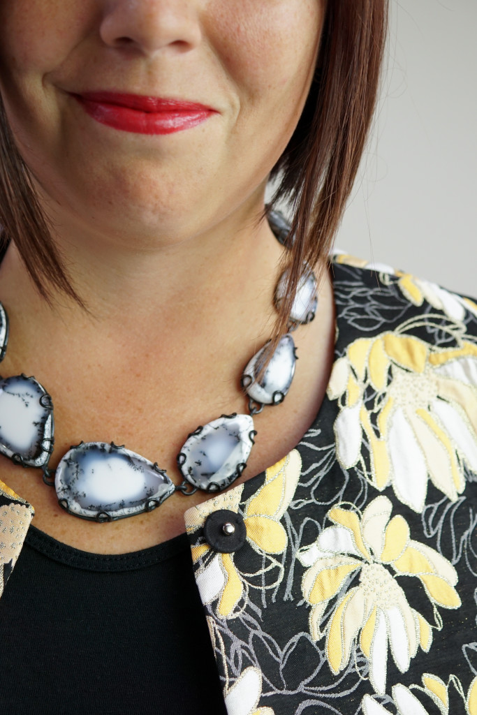 black and white gemstone statement necklace with embroidered floral coat