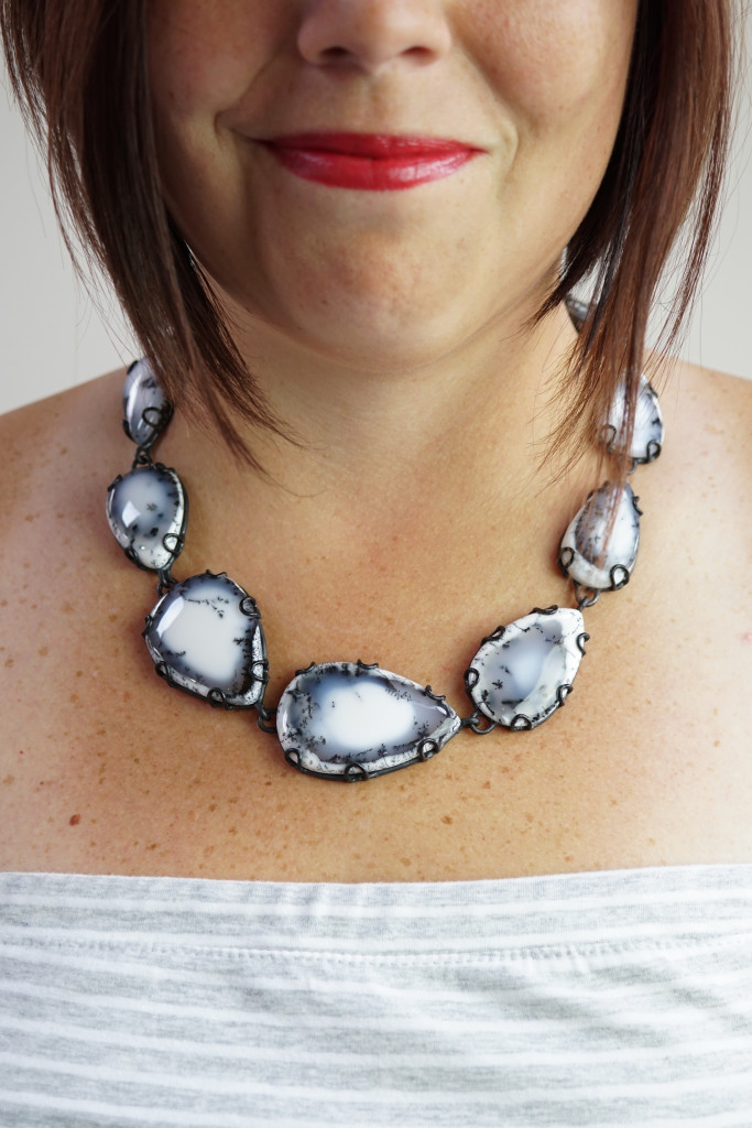 black and white gemstone statement necklace with grey and white strapless dress