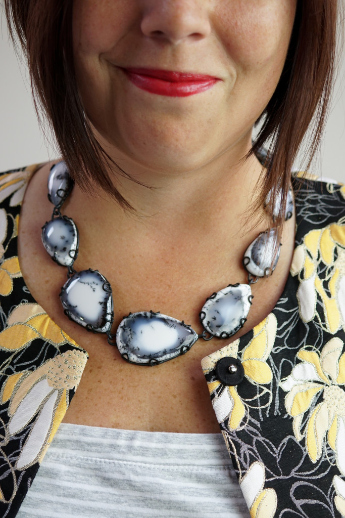 black and white gemstone statement necklace with embroidered floral coat