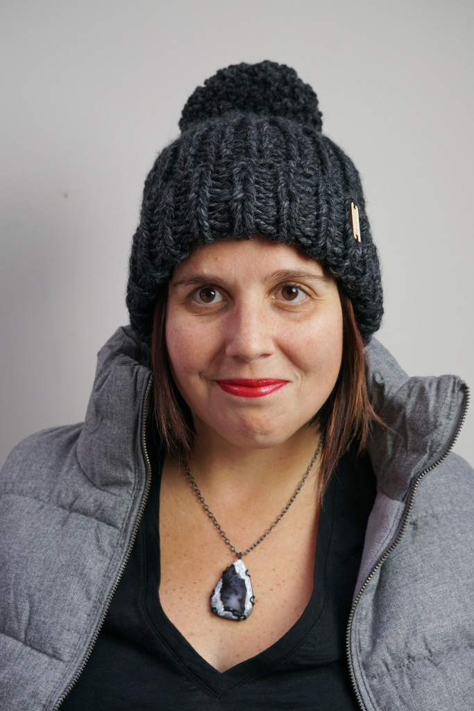 winter style: puffer vest, knit hat, and black gemstone necklace