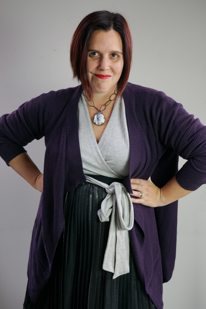 one dress thirty ways creative outfit inspiration: grey wrap dress, black metallic skirt, oversized purple cardigan, and chunky gemstone necklace