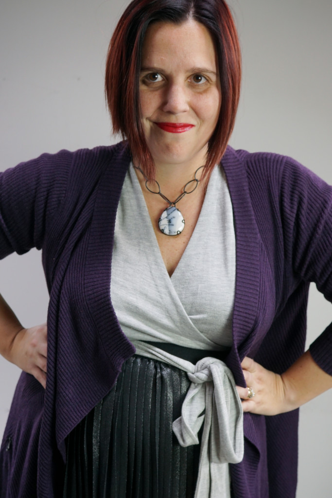 one dress thirty ways creative outfit inspiration: grey wrap dress, black metallic skirt, oversized purple cardigan, and chunky gemstone necklace