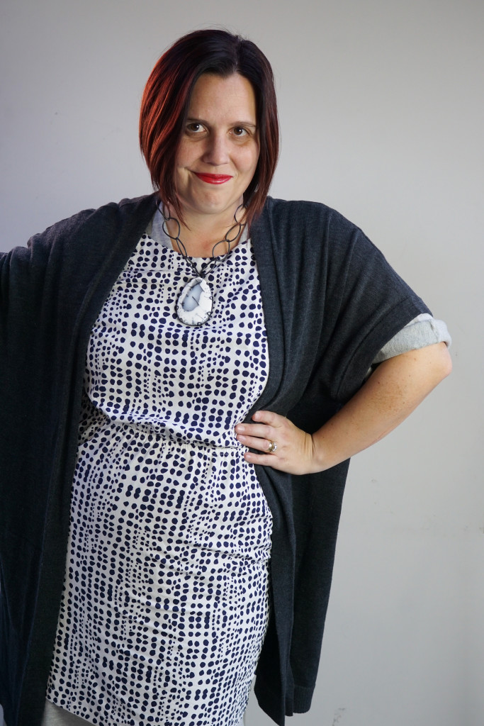 one dress challenge, creative outfit layering: oversized cardigan and patterned dress over wrap dress with chunky gemstone statement necklace