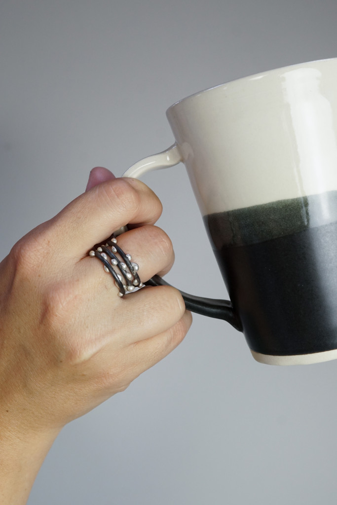 handmade ceramic mug by Bella Joy Pottery and silver on steel unique handmade mixed metal stacking rings by Megan Auman