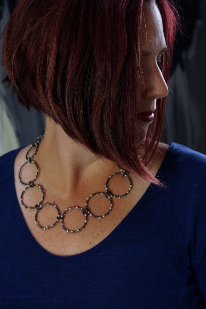 handcrafted mixed metal statement necklace by metalsmith megan auman worn with a navy t-shirt