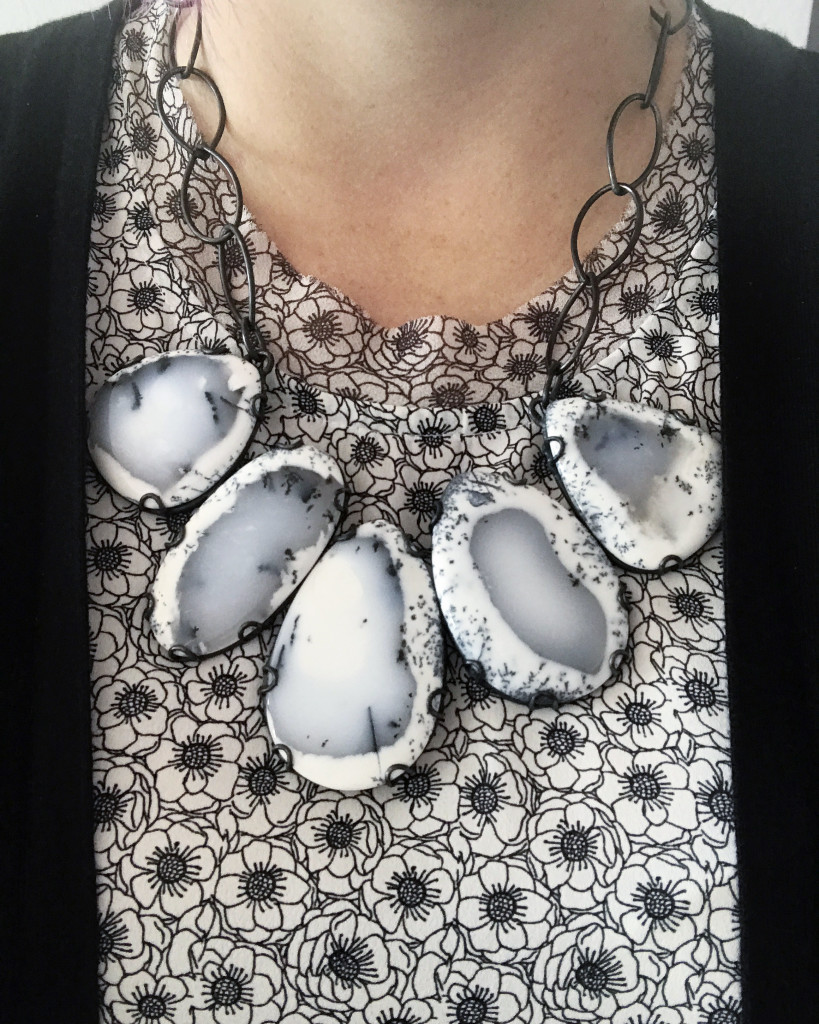 black and white gemstone statement necklace over black and white floral print shirt