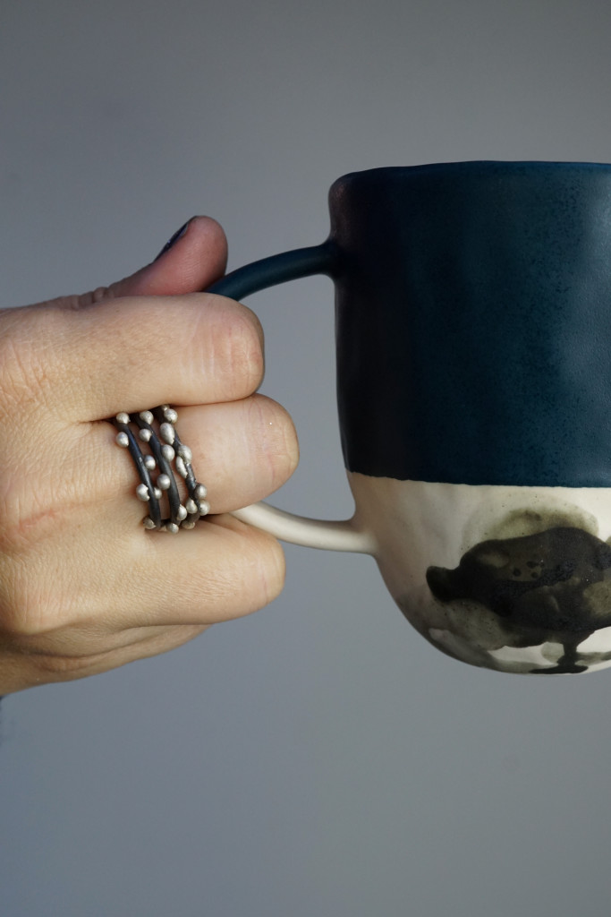 handmade ceramic mug and mixed metal silver on steel stacking rings