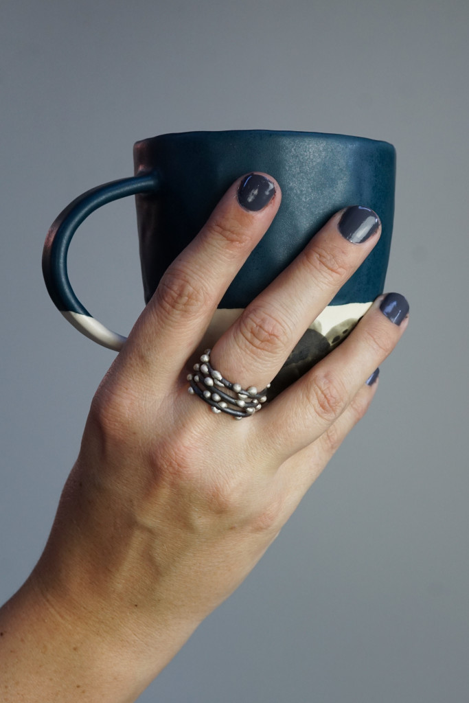 handmade ceramic mug and mixed metal silver on steel stacking rings
