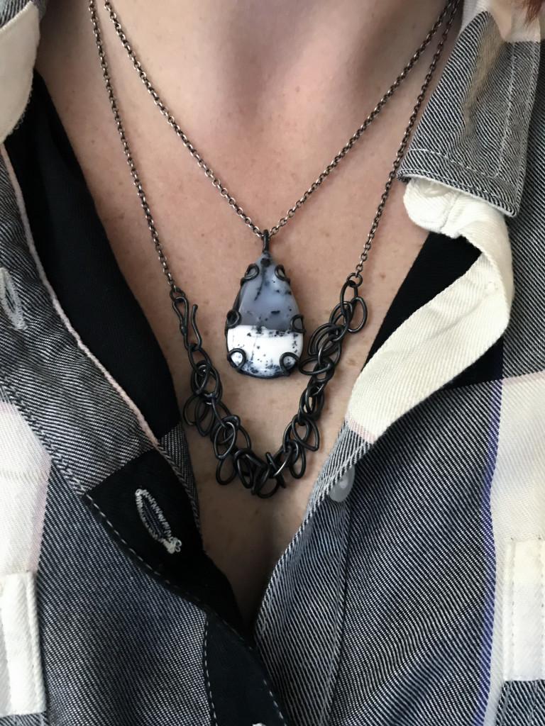 necklace layering: black chain necklace and black and white gemstone pendant with plaid shirt