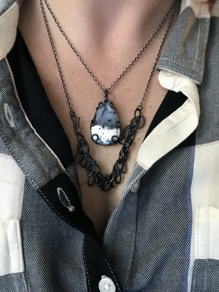 necklace layering: black chain necklace and black and white gemstone pendant with plaid shirt