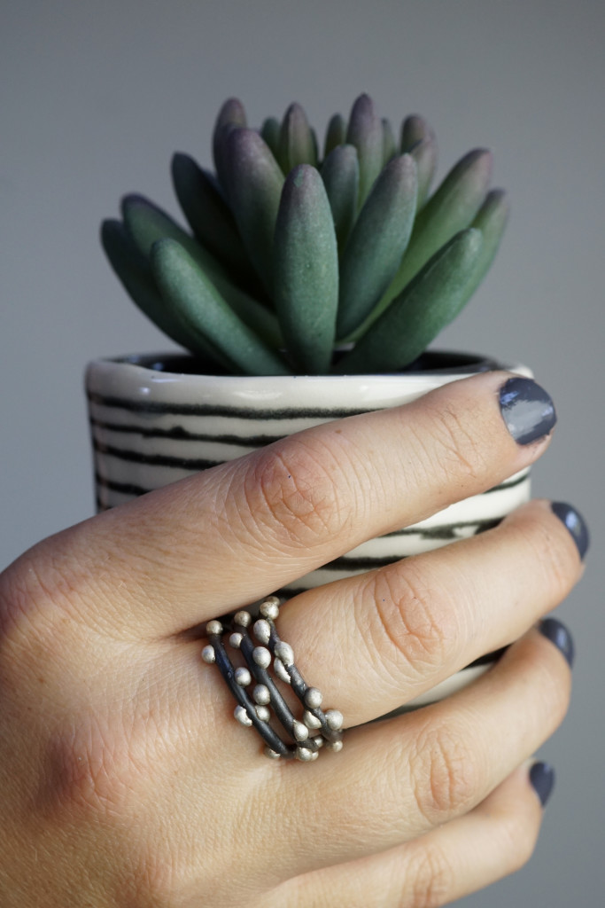 succulent, striped handmade cup, and mixed metal stacking rings