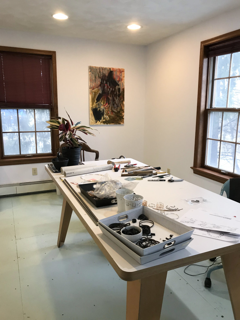 jewelry studio with plant, painting, and painted plywood floor