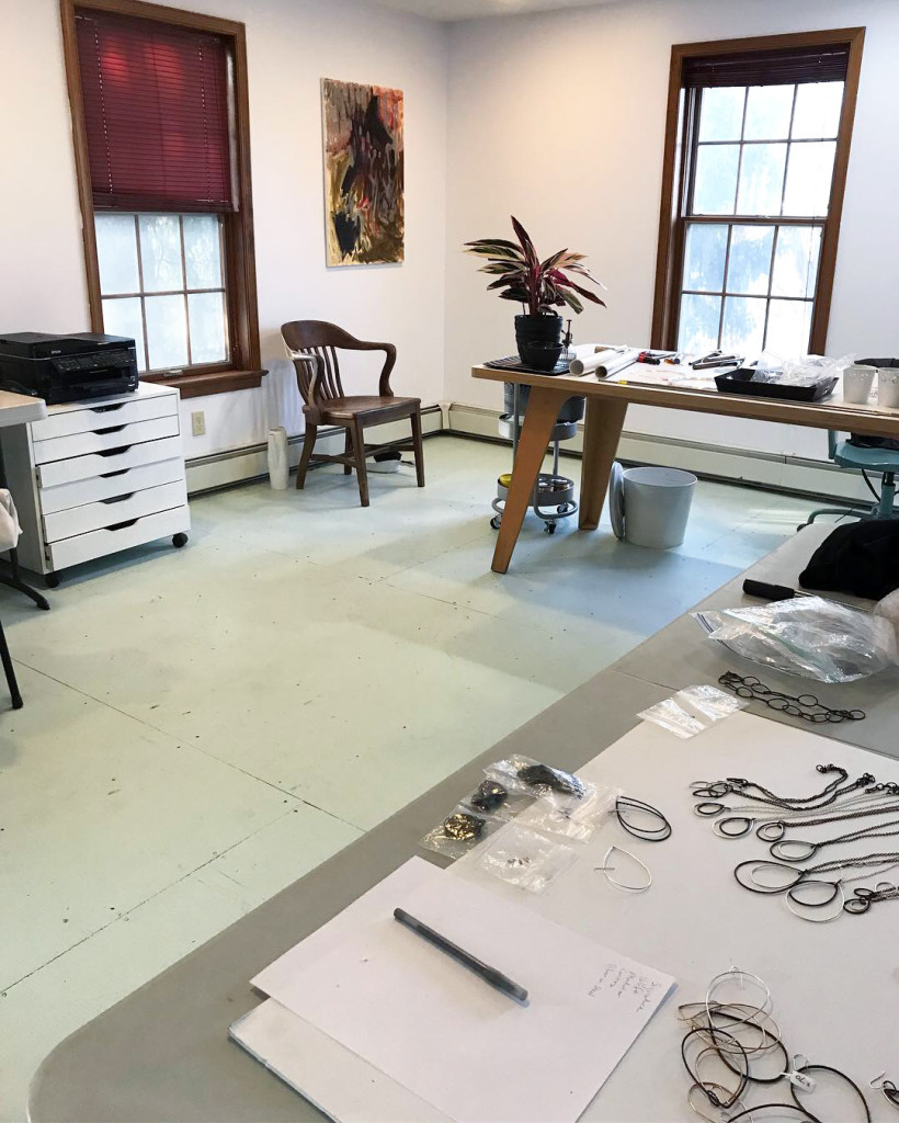 jewelry studio with plant, painting, and painted plywood floor