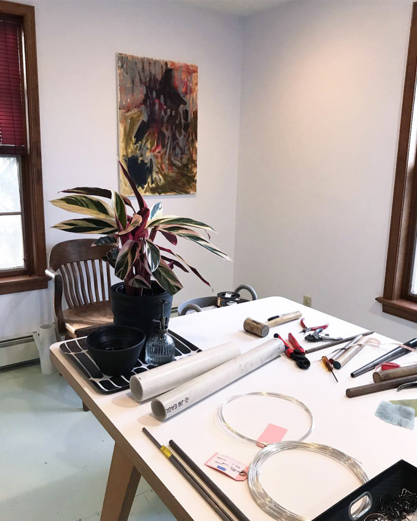 jewelry studio with plant, painting, and painted plywood floor