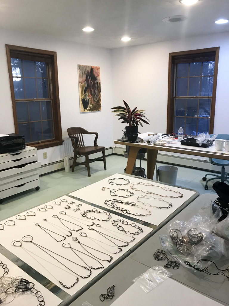 jewelry studio with plant, painting, and painted plywood floor