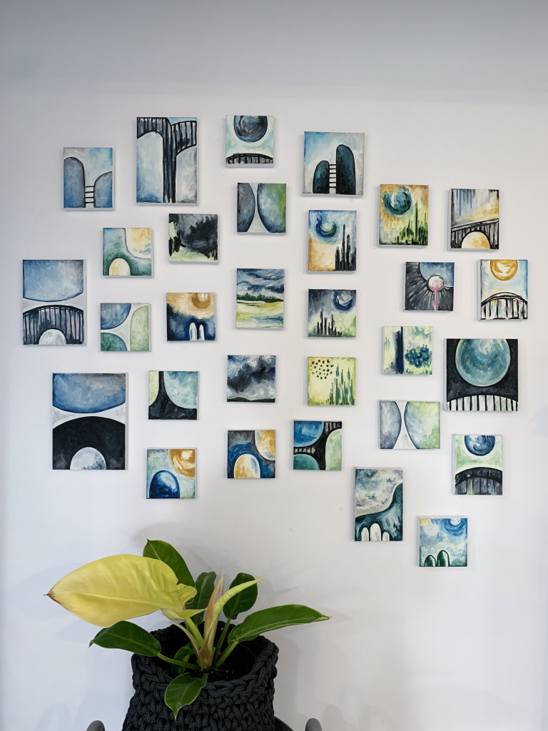 gallery wall of small paintings with plant