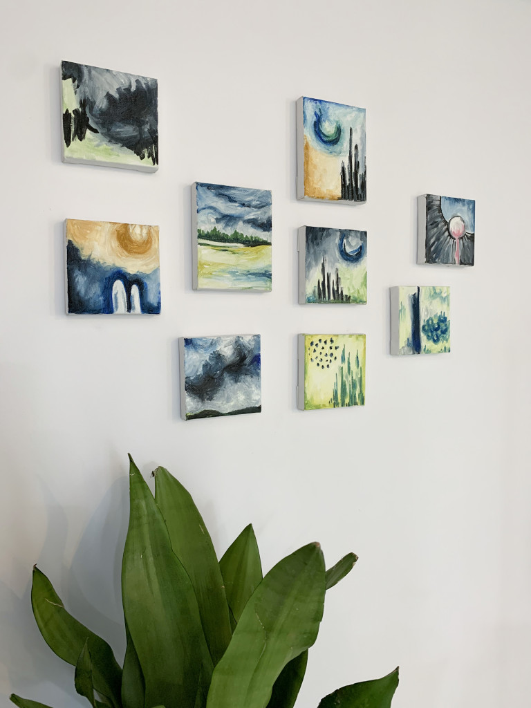 gallery wall with tiny paintings and plant