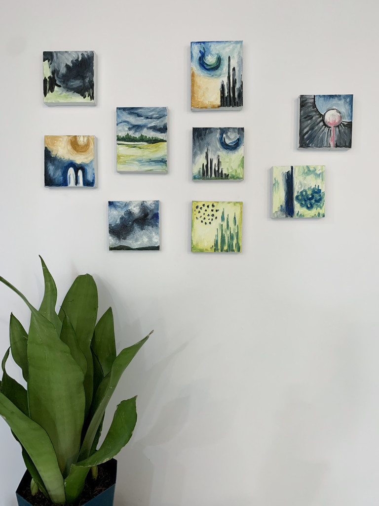 gallery wall with tiny paintings and plant