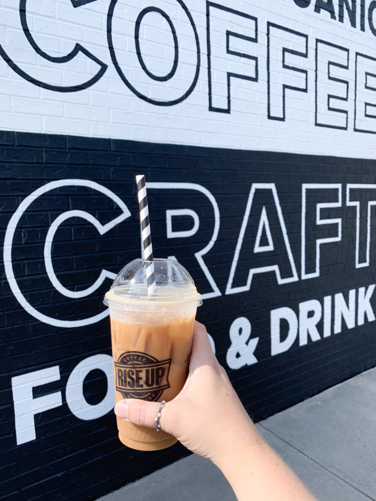 iced latte with thumb ring and black and white graphic wall