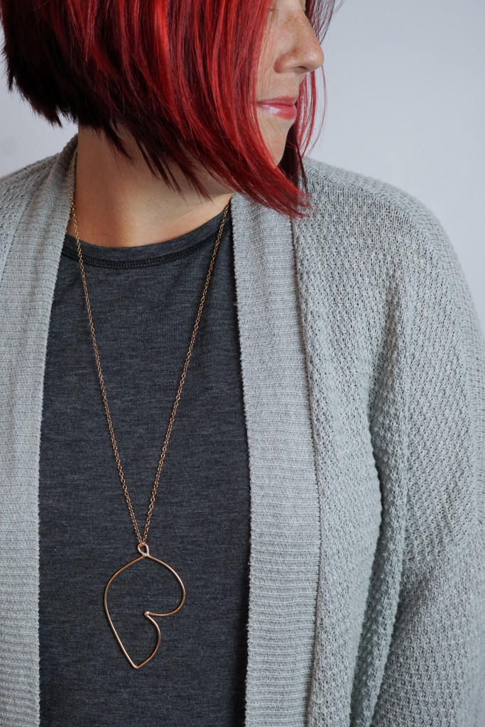 long bronze pendant with grey chunky sweater