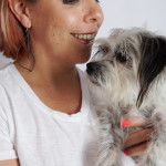 black statement earrings, a white t-shirt, and a black and white dog