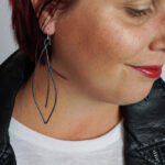 black statement earrings with a leather jacket