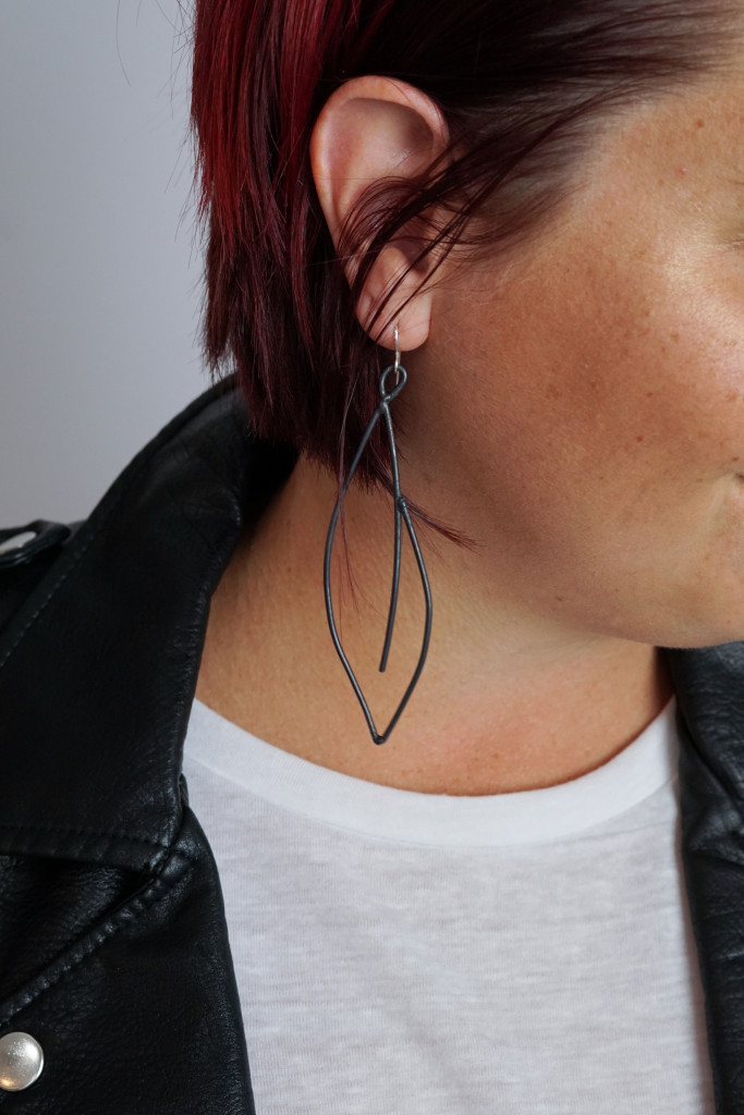 black statement earrings with leather jacket and white t-shirt