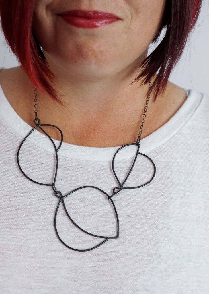 minimal art jewelry: modern graphic statement necklace on a white t-shirt