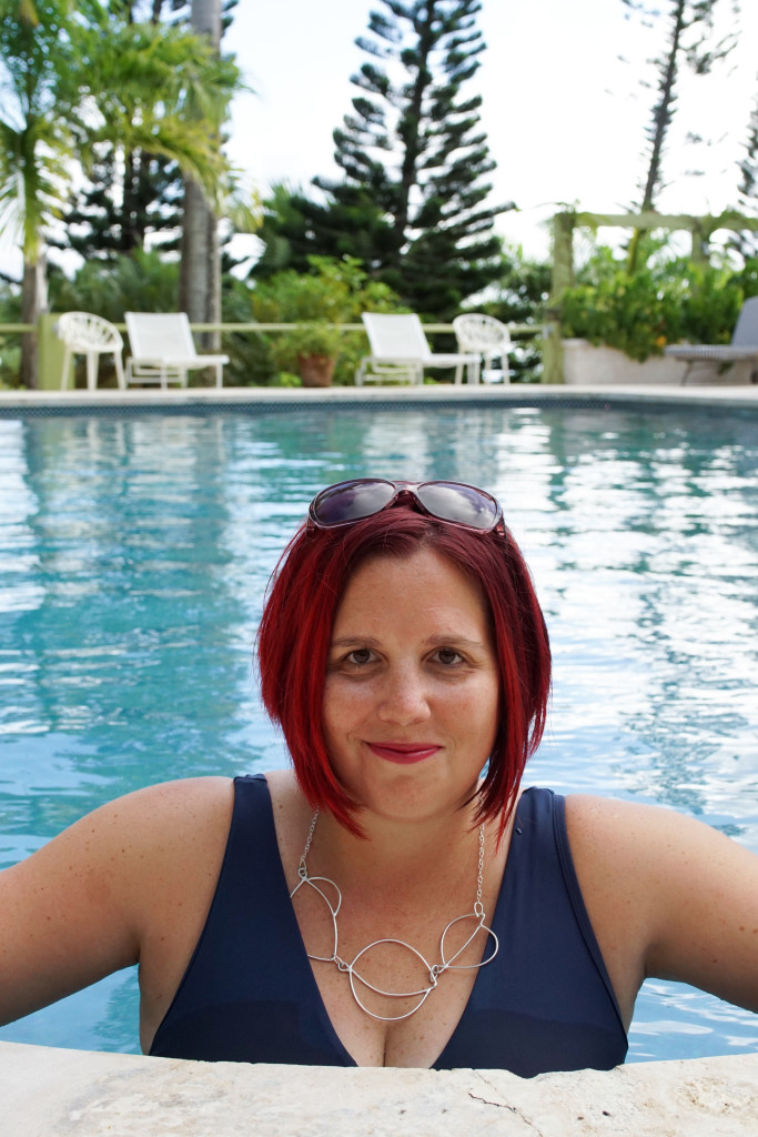 artist and jewelry designer Megan Auman wearing a statement necklace in the pool at Golden Rock Inn Nevis, West Indies, Caribbean