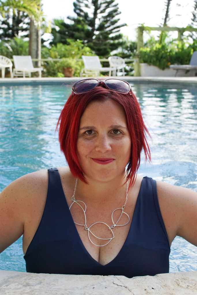 artist and jewelry designer Megan Auman wearing a statement necklace in the pool at Golden Rock Inn Nevis, West Indies, Caribbean