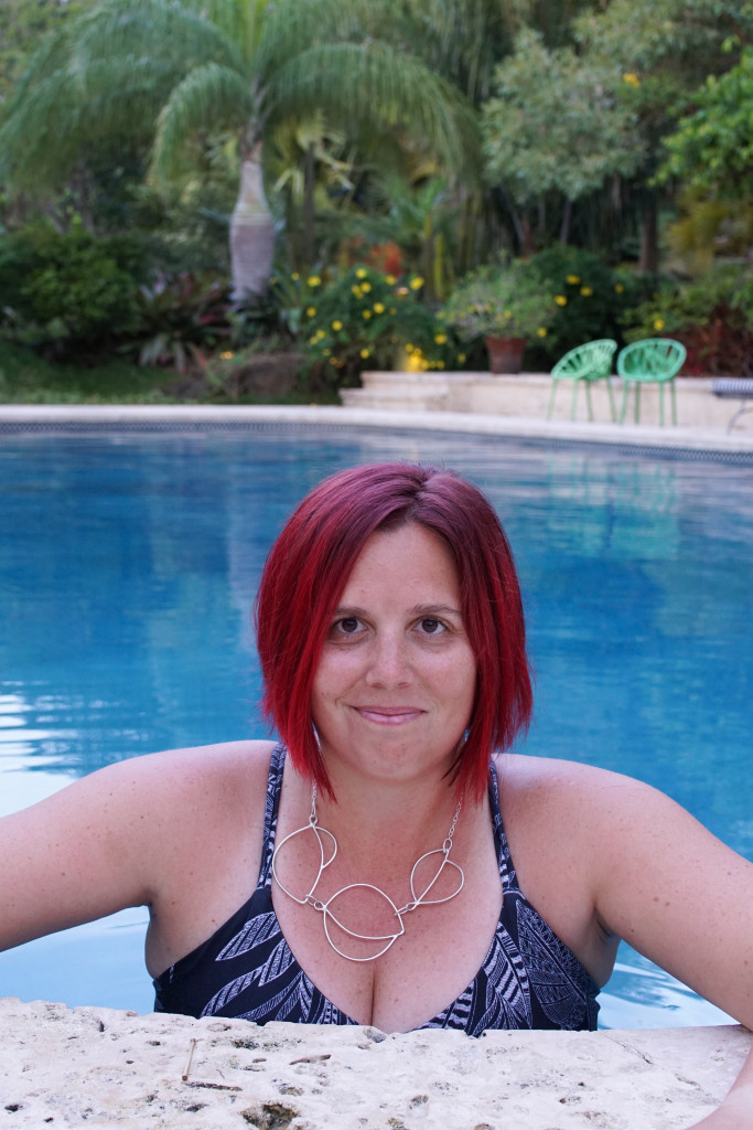 artist and metalsmith Megan Auman wearing a silver statement necklace in the pool at Golden Rock Inn Nevis, West Indies