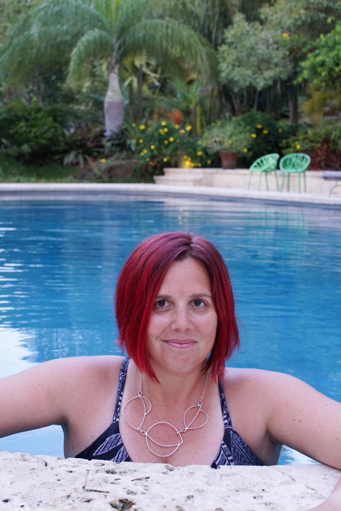 artist and metalsmith Megan Auman wearing a silver statement necklace in the pool at Golden Rock Inn Nevis, West Indies