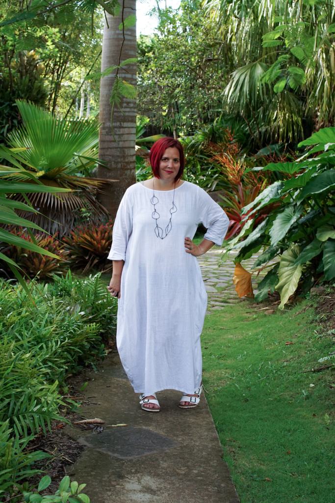 white dress and black statement necklace in the garden at Golden Rock Inn Nevis