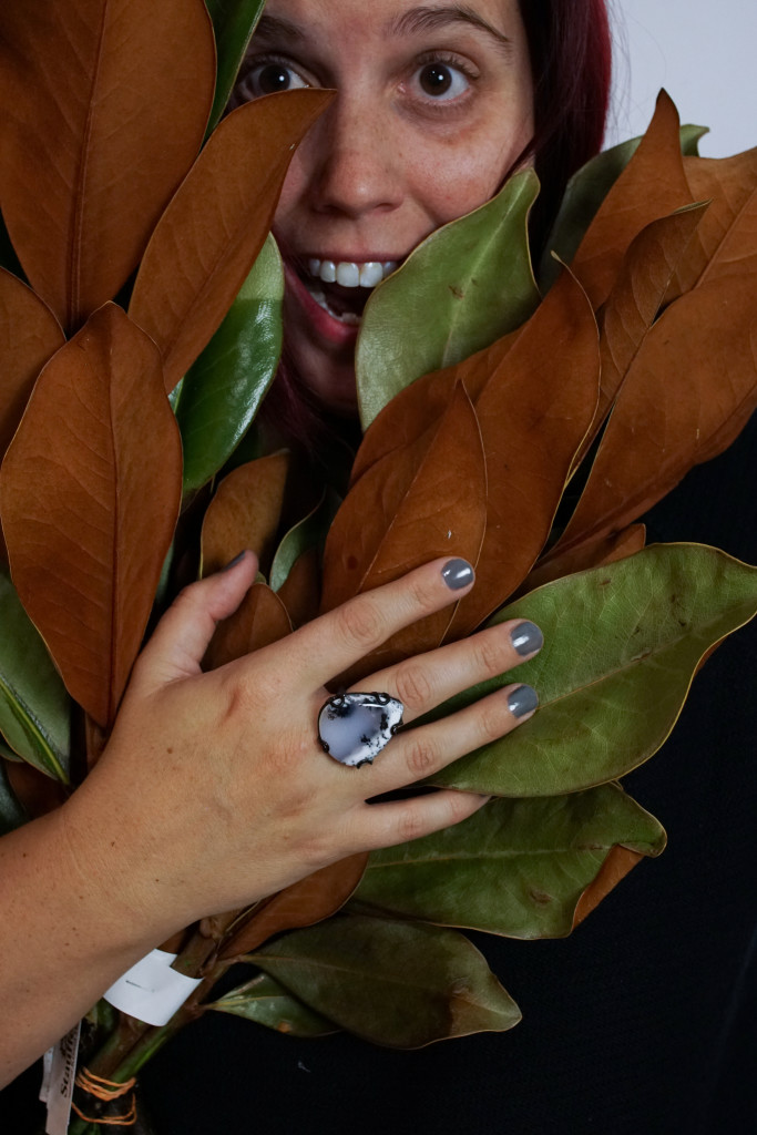 studio photography with winter foliage featuring designer and metalsmith megan auman wearing one of her signature stone and metal statement rings