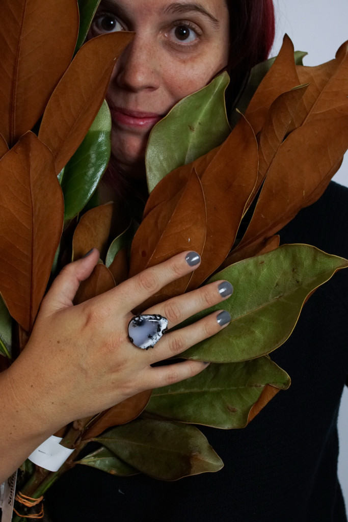 studio photography with winter foliage featuring designer and metalsmith megan auman wearing one of her signature stone and metal statement rings