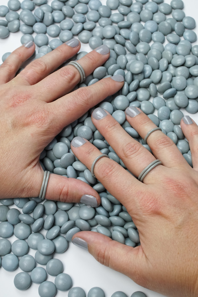 editorial jewelry photoshoot: grey stacking rings with grey M&Ms