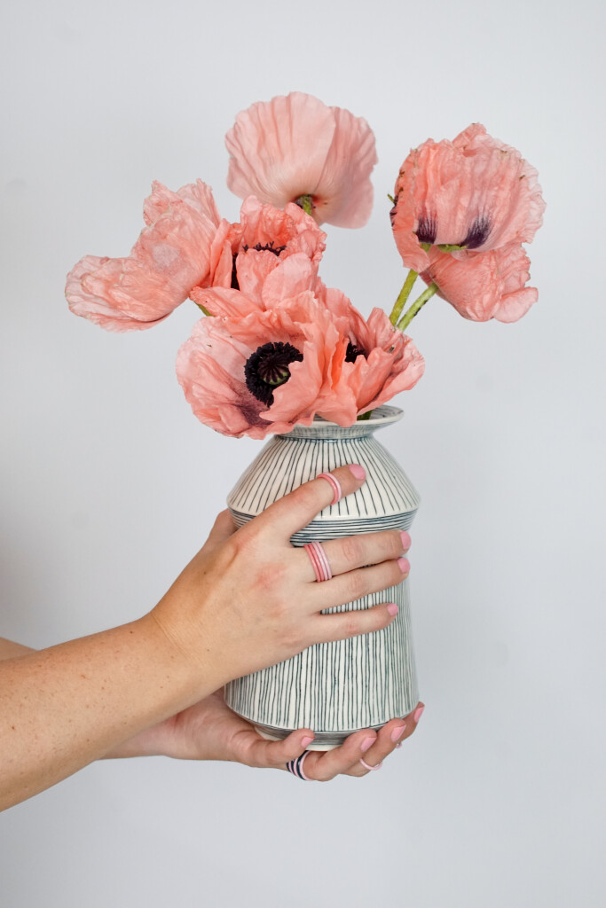 pink poppies in handmade ceramic vase with colorful stacking rings