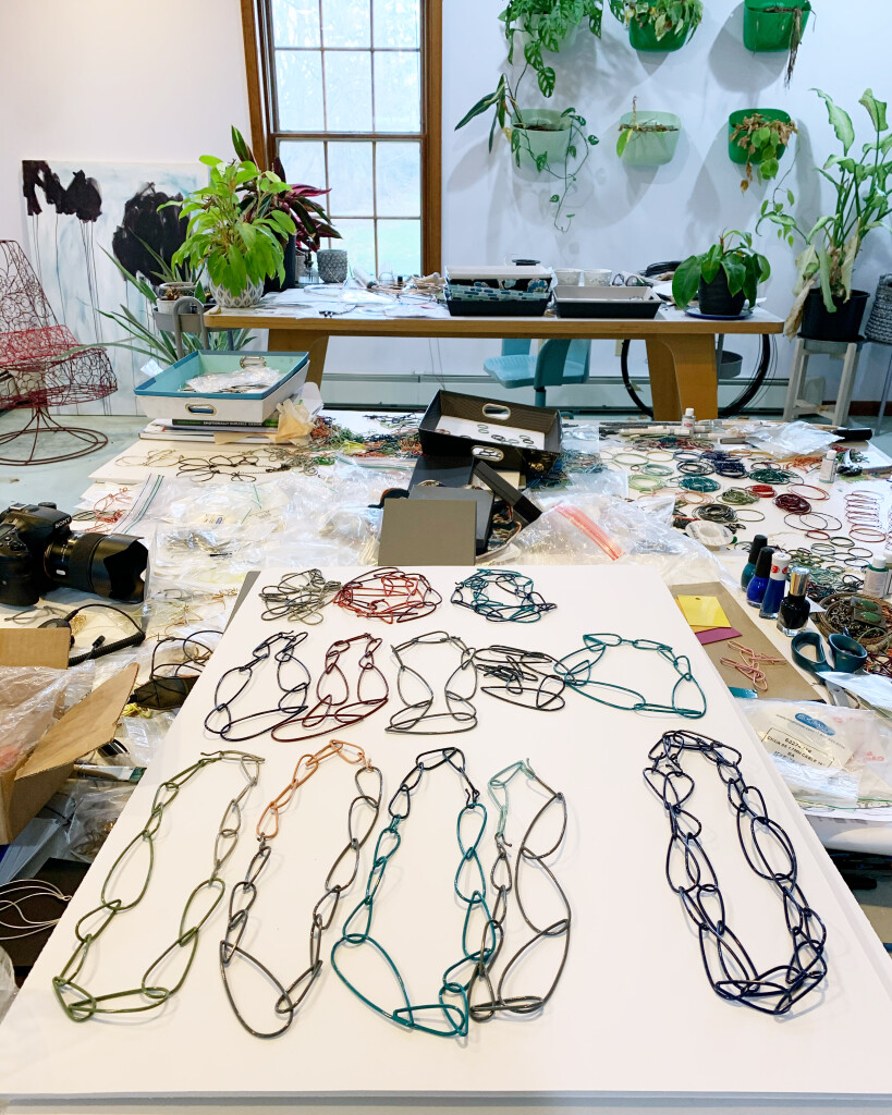 artist studio with colorful chain necklaces and plants