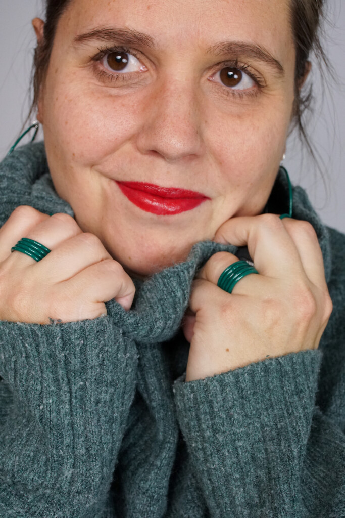 casual low key holiday style: bold lip, cozy sweater, emerald green jewelry