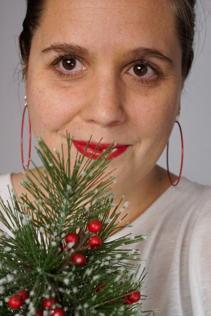 simple holiday style: bold lip, red hoop earrings, and tiny faux Christmas tree
