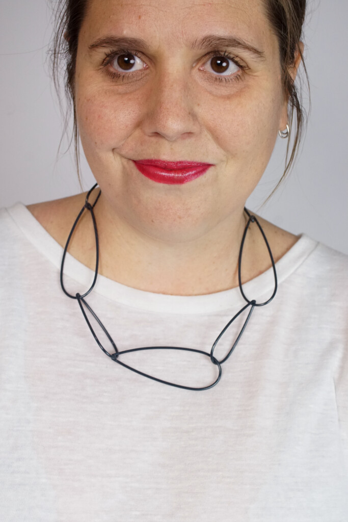 modern chunky chain necklace with white t-shirt, bold lip, and messy ponytail