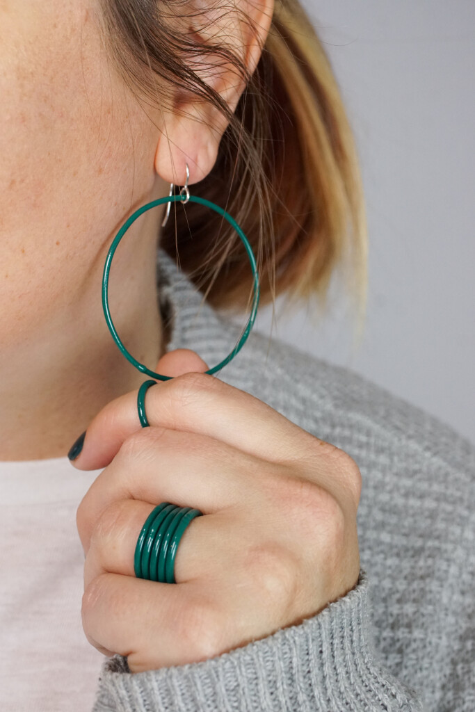 casual holiday style: large circle hoop earrings and stacking rings in emerald green
