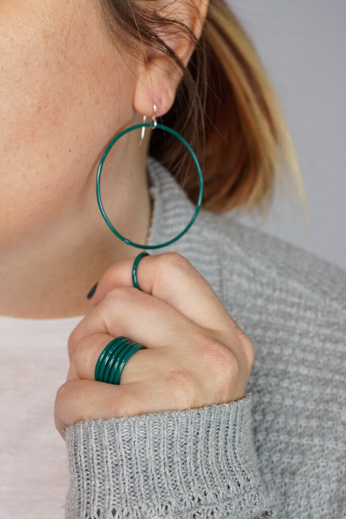 casual holiday style: large circle hoop earrings and stacking rings in emerald green