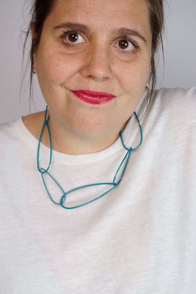 modern chunky chain necklace with white t-shirt, bold lip, and messy ponytail