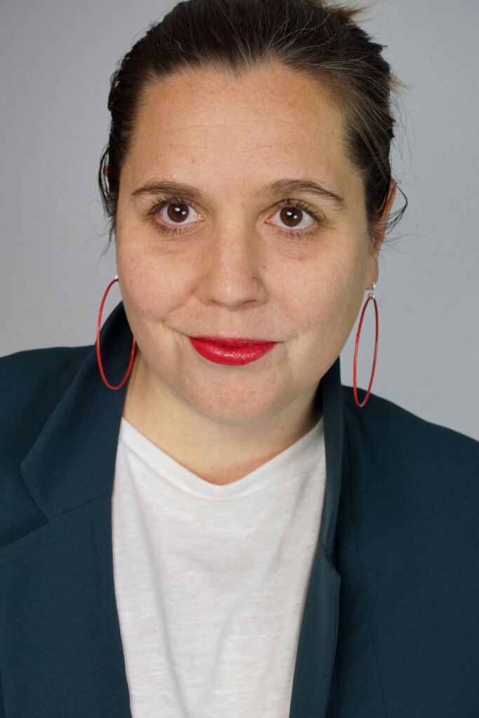 badass boss lady headshot inspiration: teal blazer, bold lip, red hoop earrings, top knot