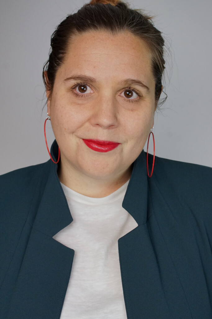 badass boss lady headshot inspiration: teal blazer, bold lip, red hoop earrings, top knot