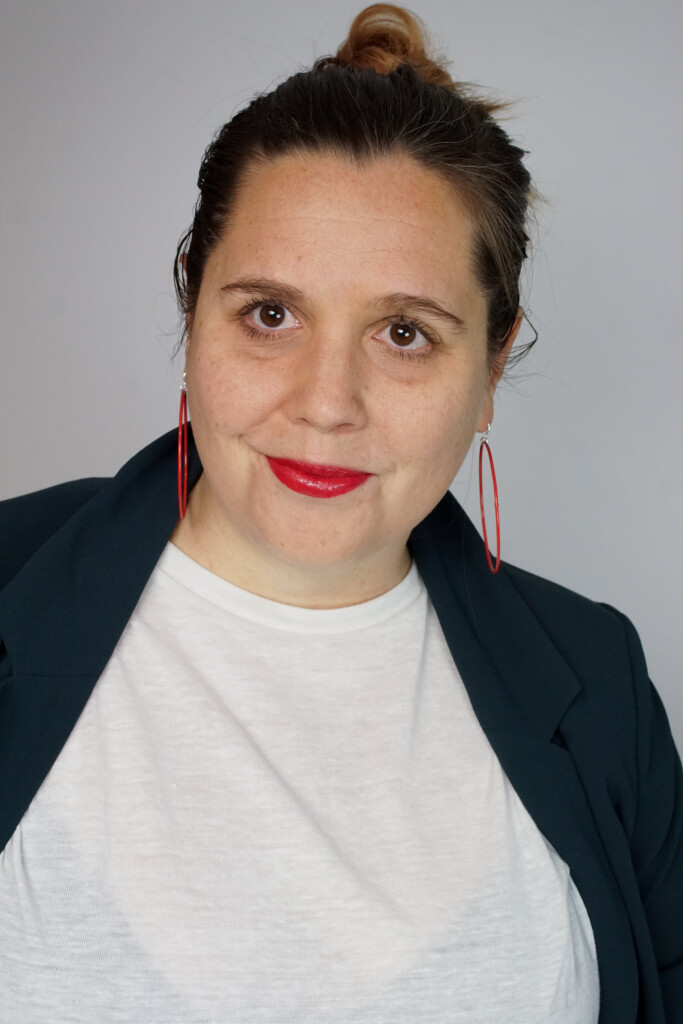 badass boss lady headshot inspiration: teal blazer, bold lip, red hoop earrings, top knot