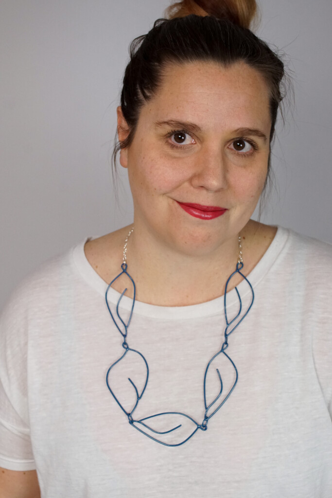 creative casual work from home style: t-shirt and top knot with a Matisse-inspired necklace