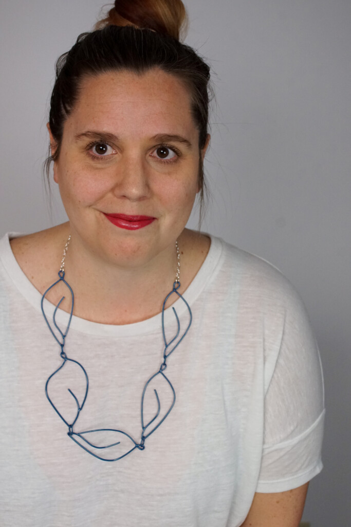 creative casual work from home style: t-shirt and top knot with a Matisse-inspired necklace