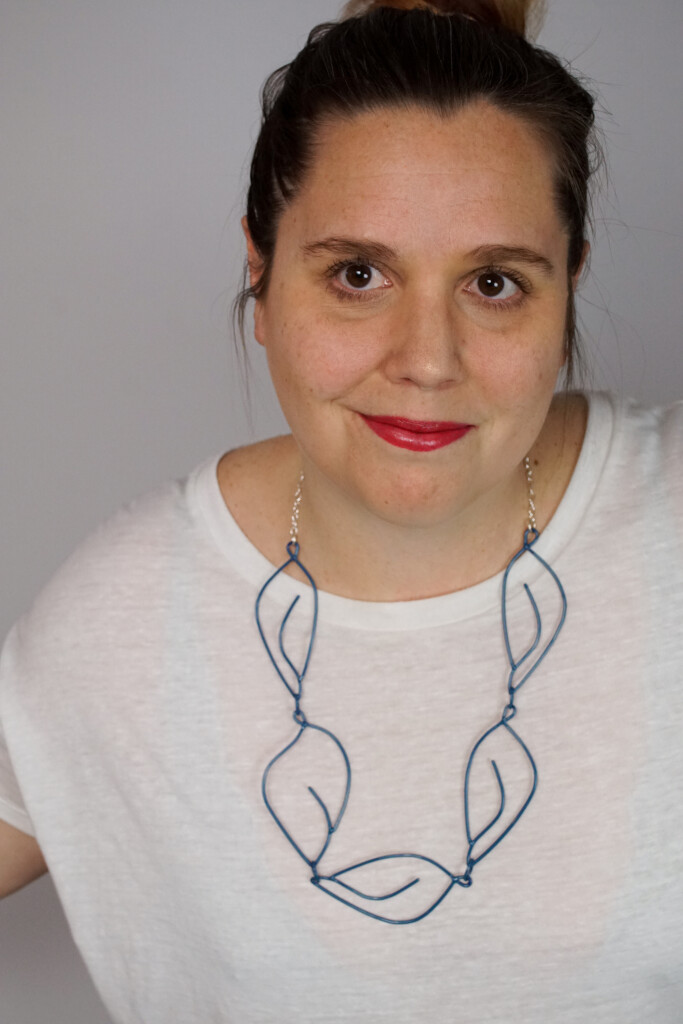 creative casual work from home style: t-shirt and top knot with a Matisse-inspired necklace